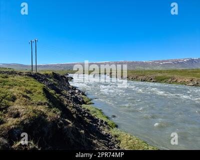 Fantastische Landschaft mit fließenden Flüssen und Bächen mit Felsen und Gras in Island. Stockfoto
