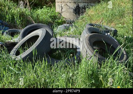 Ein Haufen alter Autoreifen liegt im Gras Stockfoto