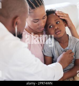 afroamerikanischer männlicher Kinderarzt, der einen kranken Jungen mit Stethoskop während des Besuchs mit mutter untersucht. Arzt prüft die Herzlunge bei der Untersuchung im Krankenhaus. Kranker oder trauriger Junge, der medizinisch versorgt wird Stockfoto