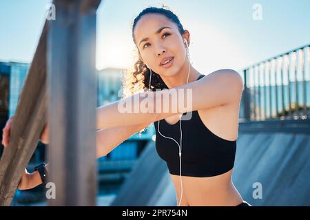 Shes bereit für ein Workout. Eine kurze Aufnahme einer attraktiven jungen Sportlerin, die sich aufwärmt, bevor sie in der Stadt ihren Lauf beginnt. Stockfoto