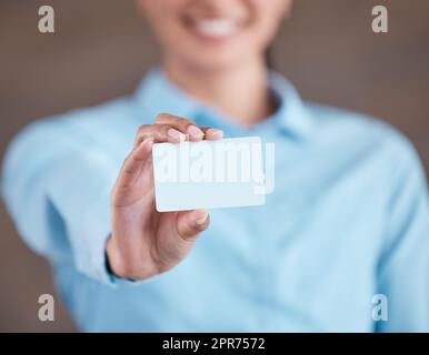 Nahaufnahme der weiblichen Hand mit Visitenkarte. Nahaufnahme einer Geschäftsfrau, die leeres Papier hochhält. Hand mit leerer weißer Karte, Mockup Stockfoto