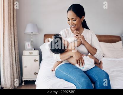 Du bist mein Stolz und meine Freude. Aufnahme einer attraktiven jungen Frau, die zu Hause auf dem Bett sitzt und ihre kleine Tochter mit einer Flasche füttert. Stockfoto