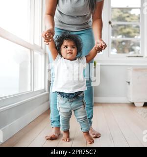 Shes wachsen zu schnell. Aufnahme eines kleinen Mädchens, das mit Hilfe ihrer Mutter laufen lernt. Stockfoto