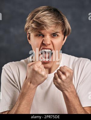 Junger Mann im T-Shirt, der mit Boxgeste steht Stockfoto