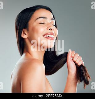 Lass es locker. Studioaufnahme einer schönen jungen Frau mit langen braunen Haaren. Stockfoto