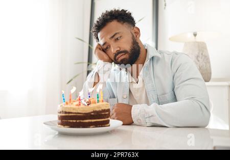 Wenn niemand zu deinem Geburtstag aufkommt. Aufnahme eines jungen Mannes, der zu Hause seinen Geburtstag allein feiert. Stockfoto