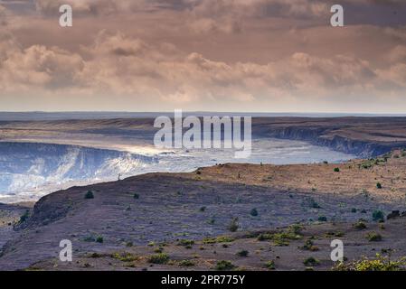 Landschaft mit gekühltem Lavafluss auf Big Island von Hawaii. Malerischer Blick auf Mauna Kea, einen ruhenden Vulkan in einer abgelegenen Gegend mit Kopierbereich. Weitläufige Natur und wolkiger Himmel nahe dem Gipfel des vulkanischen Landes Stockfoto