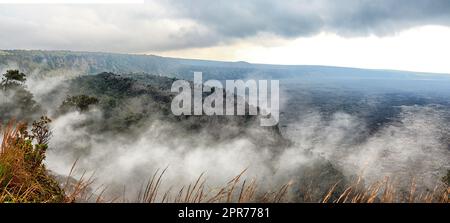 Landschaft mit nebligen Bergen auf Big Island Hawaii. Malerischer Blick auf Mauna Kea, ruhender Vulkan in einer abgelegenen Gegend. Riesige neblige Ausdehnung der Natur und bewölkter Himmel nahe dem Gipfel des vulkanischen Landes Stockfoto