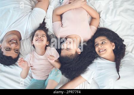 Keine freien Tage in diesem Zeitplan. Aufnahme einer schönen jungen Familie, die im Bett miteinander redet und sich verbindet. Stockfoto