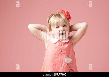 Ich kann es kaum erwarten, zu sehen, was es ist. Aufnahme eines niedlichen kleinen Mädchens vor einem Studiohintergrund. Stockfoto