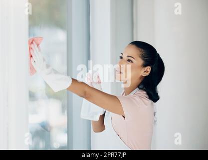 Chores vor allem anderen. Aufnahme einer Frau, die zu Hause das Fenster putzt. Stockfoto