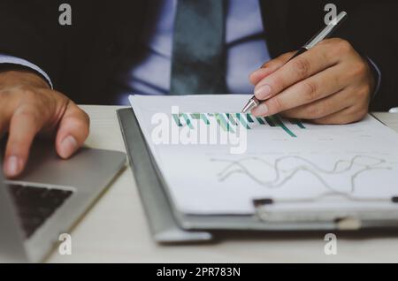 Geschäftsmann hält Stift, um Computer-Grafiken und Diagramme Daten statistische Daten Finanzanalyse Dokumente zu arbeiten. Stockfoto