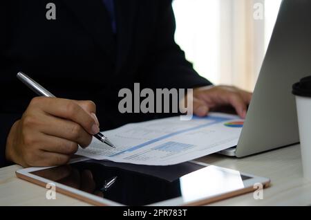 Geschäftsmann hält Stift, um Computer-Grafiken und Diagramme Daten statistische Daten Finanzanalyse Dokumente zu arbeiten. Stockfoto