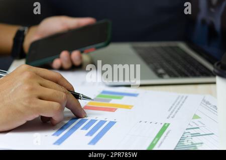 Geschäftsmann hält Stift, um Computer-Grafiken und Diagramme Daten statistische Daten Finanzanalyse Dokumente zu arbeiten. Stockfoto