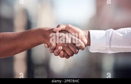 Ermöglicht die Zusammenarbeit. Kurzer Schuss von zwei nicht erkennbaren Geschäftsleuten, die sich draußen die Hände schüttelten. Stockfoto