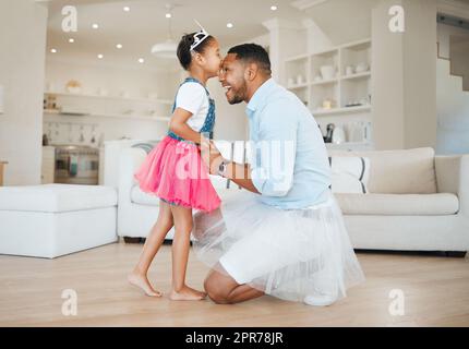 Familie macht dich, wer du bist und wer du bist. Aufnahme eines kleinen Mädchens, das ihrem Vater zu Hause einen Kuss gab. Stockfoto