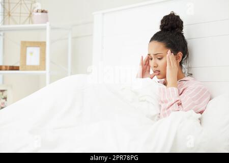 Ich habe das Gefühl, dass ich meinen Verstand verliere. Aufnahme einer jungen Frau, die gestresst im Bett sitzt. Stockfoto