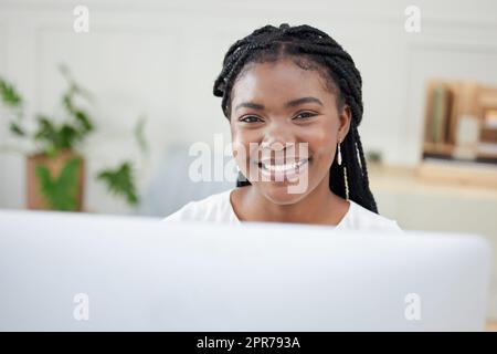 Das Geschäft boomt in letzter Zeit. Aufnahme einer jungen afrikanischen Geschäftsfrau, die an ihrem Computer arbeitet. Stockfoto