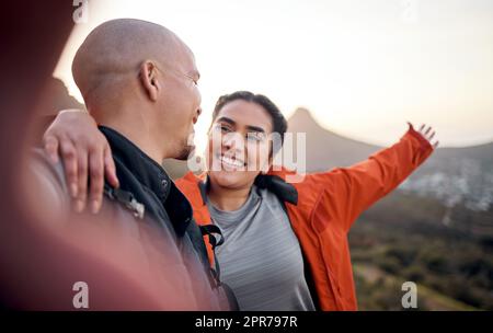 Hier oben ist der beste Anblick. Beschnittenes Porträt eines liebevollen jungen Paares, das Selfies beim Wandern in den Bergen macht. Stockfoto