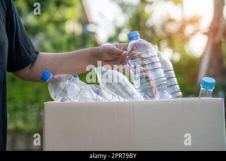 Asiatische Frau Freiwillige tragen Wasser Plastikflaschen in Müllkiste Müll im Park, recyceln Abfall Umwelt Ökologie Konzept. Stockfoto