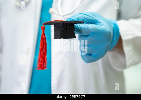 Asiatische Arzt Studie lernen mit Abschluss GAP Hut in Krankenhausstation, clever hell Genie Bildung Medizin Konzept. Stockfoto