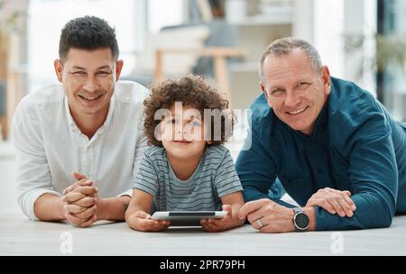 Immer bereit, Zeit miteinander zu verbringen. Ein junger Mann verbringt Zeit mit seinem Vater und seinem Sohn, während er ein digitales Tablet benutzt. Stockfoto