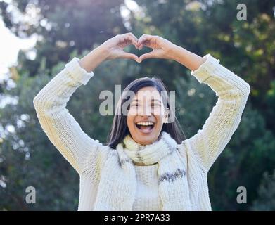 Du bist das Besondere für mich. Eine Frau, die eine Herzform mit ihren Händen über ihrem Kopf formt. Stockfoto