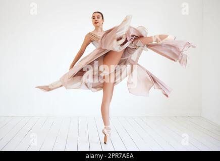 Tanzen ist ihr Leben. Ganzkörperaufnahme einer attraktiven jungen Ballerina, die in ihrem Tanzstudio praktiziert. Stockfoto