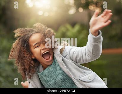 Ein bezauberndes junges Mädchen, das draußen im Garten spielt. Stockfoto