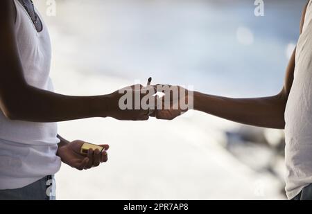 Puff, Puff, Pass. Zwei unkenntliche Männer rauchen eine Marihuana-Zigarette. Stockfoto