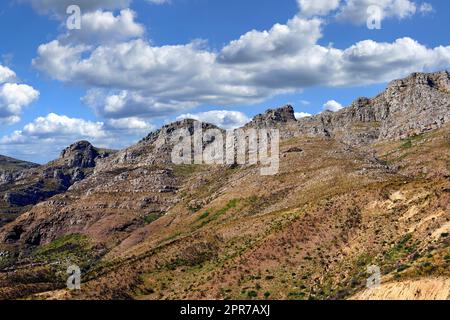 Landschaftsblick auf zwölf Apostel, Kapstadt im Westkap, Südafrika. Wunderschöne Landschaft einer beliebten Touristenattraktion während des Tages vor einem wolkigen blauen Himmel. Naturdenkmal für Wanderungen Stockfoto