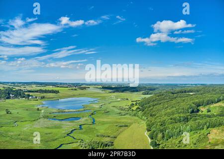 Landschaften von Jütland, Dänemark. Wunderschöne Landschaft, die die dänische Wildnis zeigt. Weiden an einem hellen Sommertag mit üppigem Grün und blauem Himmel voller Wolken. Stockfoto