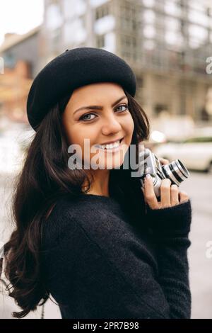 Eine Frau, die eine Retro-Kamera hält und ein Foto macht Stockfoto