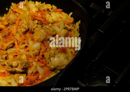 Hausgemachtes koreanisches würziges Hühnchen, Chiken mit Karotten in einer Pfanne mit Sonnenblumenöl braten. Stockfoto