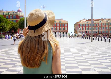 Tourismus in Frankreich. Rückansicht einer jungen Touristenfrau, die auf dem Massena-Platz in Nizza, Frankreich, spazierengeht. Stockfoto