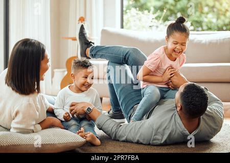 Eine junge Familie spielt zu Hause auf der Lounge-Etage zusammen. Stockfoto