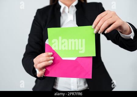 Eine Elegante Geschäftsfrau, Die Wichtige Memoranden In Einen Briefumschlag Legt. Frau Im Anzug Hält Geschäftsbrief In Händen Und Sendet Wichtige Botschaft Per Post. Stockfoto