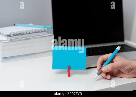 Geschäftsfrau, Die Einen Stift Auf Dem Schreibtisch Mit Laptop, Bücher Und Notizen Mit Wichtigen Daten Hält. Frau Mit Bleistift In Einer Hand Am Tisch Mit Computer, Notizbüchern Und Memo Mit Neuen Ideen. Stockfoto