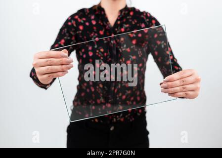 Geschäftsfrau, Die Rechteckiges Glas Hält, Während Sie Wichtige Daten Anzeigt. Frau trägt ein T-Shirt mit Blumenmuster und zeigt während der Werbung für das Unternehmen ein transparentes Banner. Stockfoto