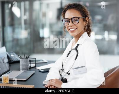 Als Arzt musst du deinen Administrator erledigen. Ein Porträt einer attraktiven jungen Ärztin, die an ihrem Schreibtisch im Büro arbeitet. Stockfoto