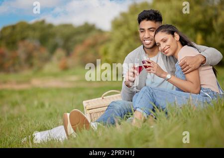 Sie verdienen jemanden, der Ihnen das Gefühl gibt, etwas Besonderes zu sein. Ein junges Paar, das während eines Picknicks anstoßen kann. Stockfoto