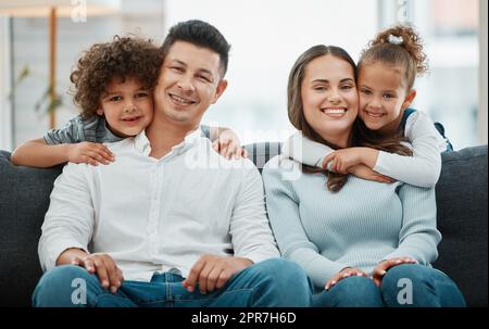 Unsere Kinder sind unsere Freude. Ein junges Paar wird von ihren Kindern umarmt. Stockfoto