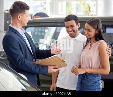 Das Beste ist, dass wir bieten Finanzen. Ein Autoverkäufer Unterstützung eines jungen Paares auf der Ausstellungsfläche. Stockfoto