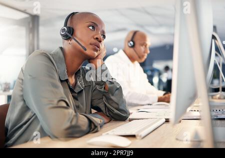 Gestresster afroamerikanischer Callcenter-Telemarketing-Agent, der gelangweilt und besorgt aussah, während er an einem kaputten Computer in einem Büro arbeitete. Beunruhigte Beraterin hat Probleme mit langsamen Internetverbindungsfehlern. Fauler Angestellter, der mit der schwierigen calle zu kämpfen hat Stockfoto