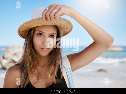 Eine wunderschöne junge weiße Frau, die sich am Strand entspannt. Genießen Sie einen Sommerurlaub oder einen Urlaub im Freien im Sommer. Sich frei nehmen und dem Alltag entfliehen. Den Tag alleine draußen zu verbringen Stockfoto