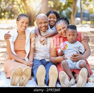 Portrait glückliche afroamerikanische Familie mit fünf Personen, die im Sommer eine schöne Zeit zusammen im Park verbringen. Großeltern, Mutter und Kinder, die sich draußen anfreunden. Ein Ausflug mit den Kindern Stockfoto