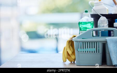 Leerer Korb mit Reinigungsprodukten mit gelben Handschuhen auf dem Boden. Eimer zum Sammeln von Reinigungsmitteln und Chemikalien auf dem Boden. Professionelle Hygiene Reinigungsprodukte auf dem Boden eines Hauses Stockfoto