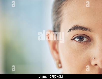 Nahaufnahme einer Frau mit gemischter Rasse, halbwegs, mit einem Nasenloch, das direkt in die Kamera schaut. Wunderschöne, junge, multiethnische Frau, die von Kopf auf sie starrt. Selbstbewusst, stolz und fest in ihrer Weiblichkeit Stockfoto