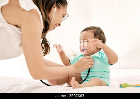 Waren fast fertig, kleiner. Nahaufnahme eines Kinderarztes mit einem Stethoskop während einer Babyuntersuchung. Stockfoto