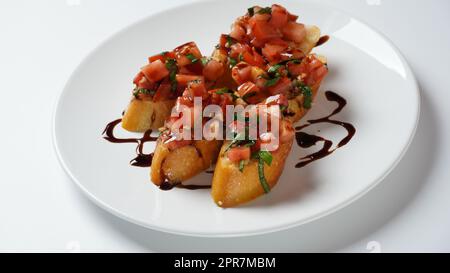 Italienische Bruschetta mit Tomaten, Basilikum, Knoblauch, Olivenöl und Käse auf knusprigem Brot Stockfoto